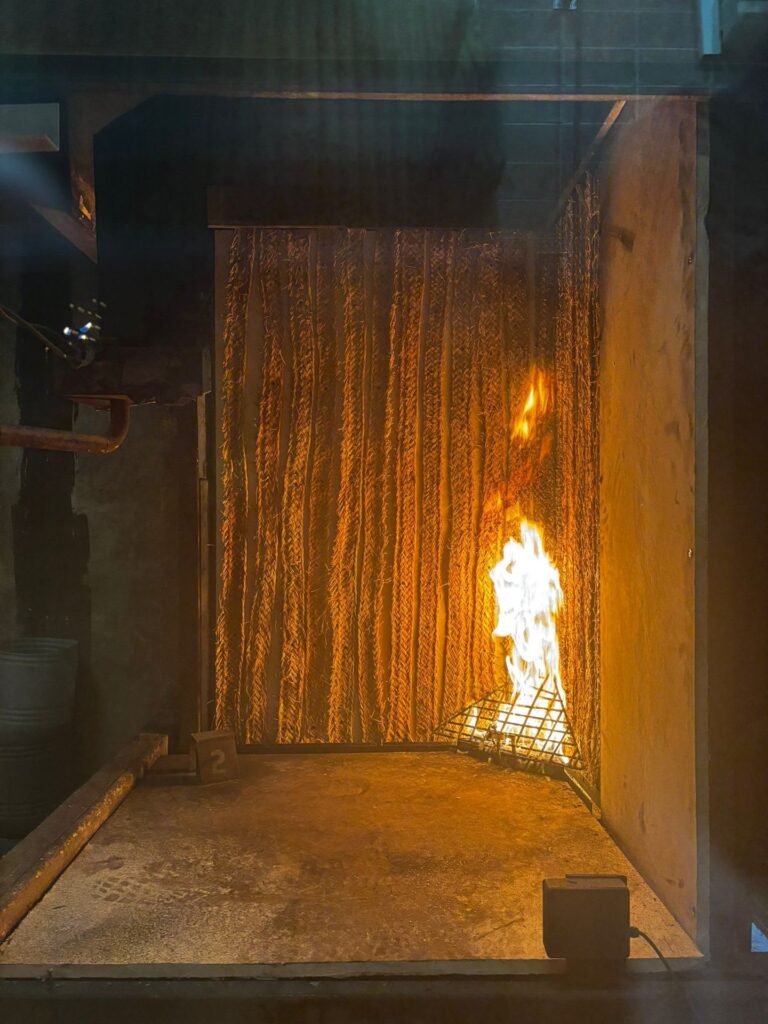 Muestra de tejido de esparto durante un ensayo de reacción al fuego