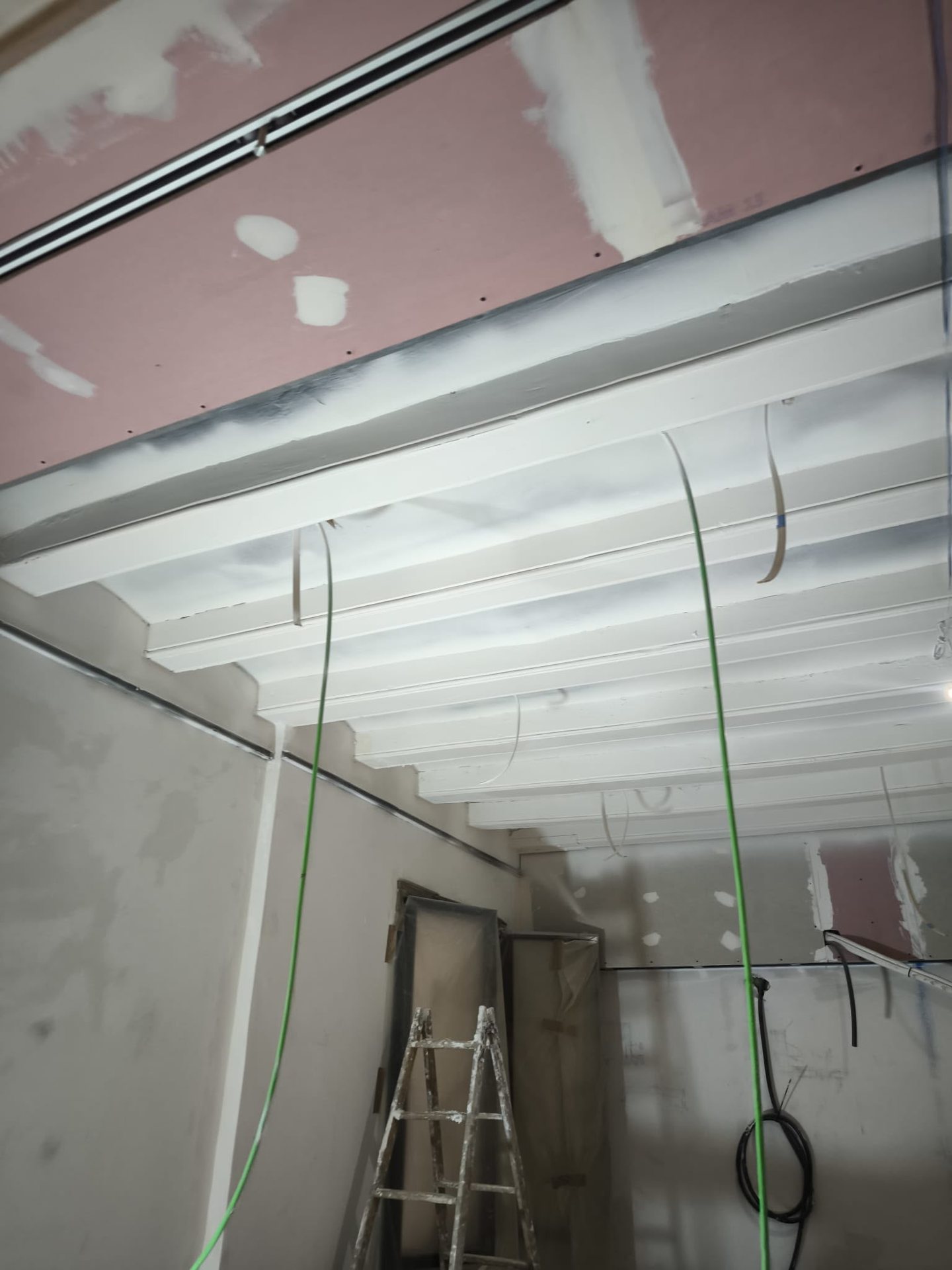 Vigas de madera con acabado blanco durante la intervención